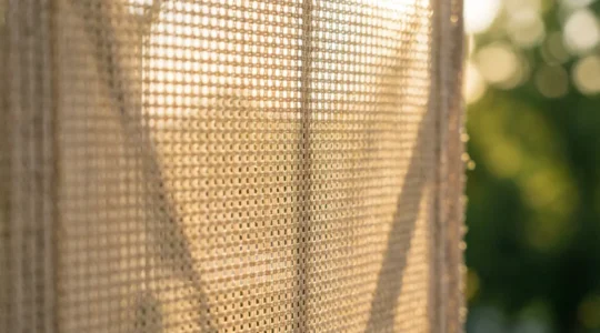 Detalle de tejido microperforado de toldo mostrando su estructura ventilada para reducción térmica